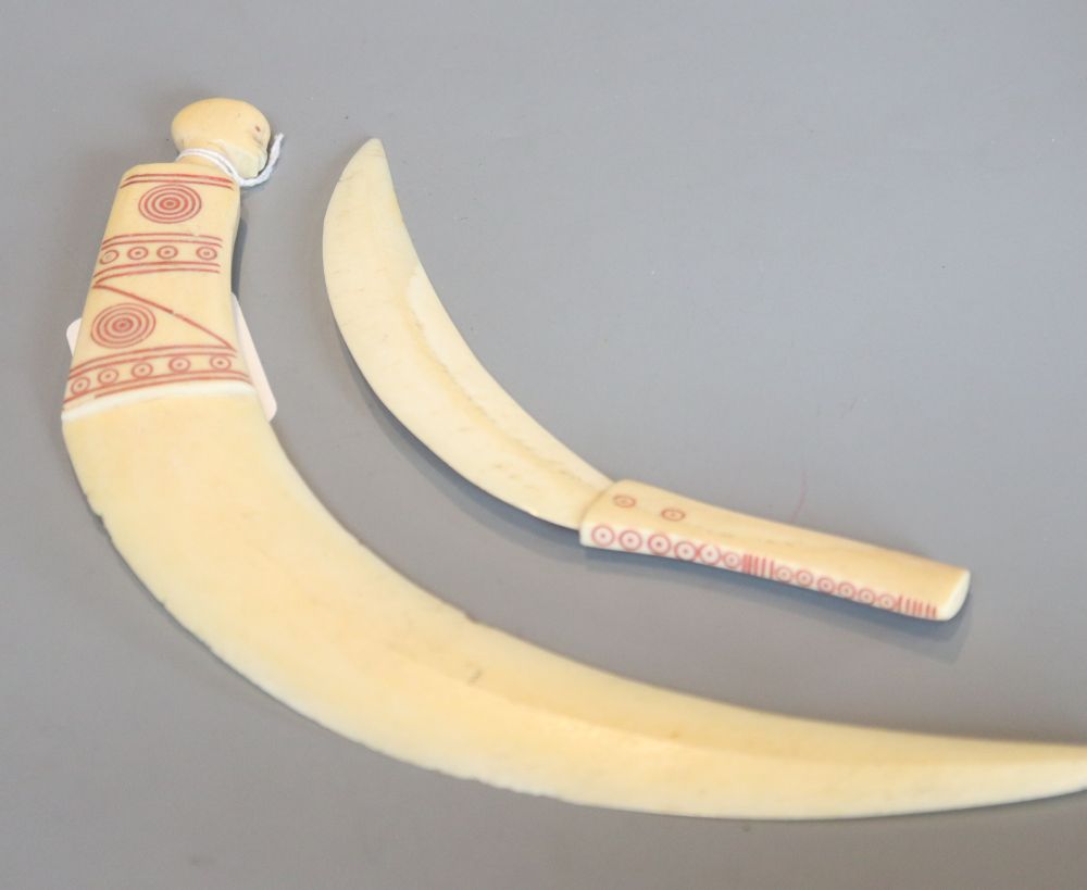 Two tribal carved warthog or boars tusk daggers, first half 20th century, picked out in red pigment